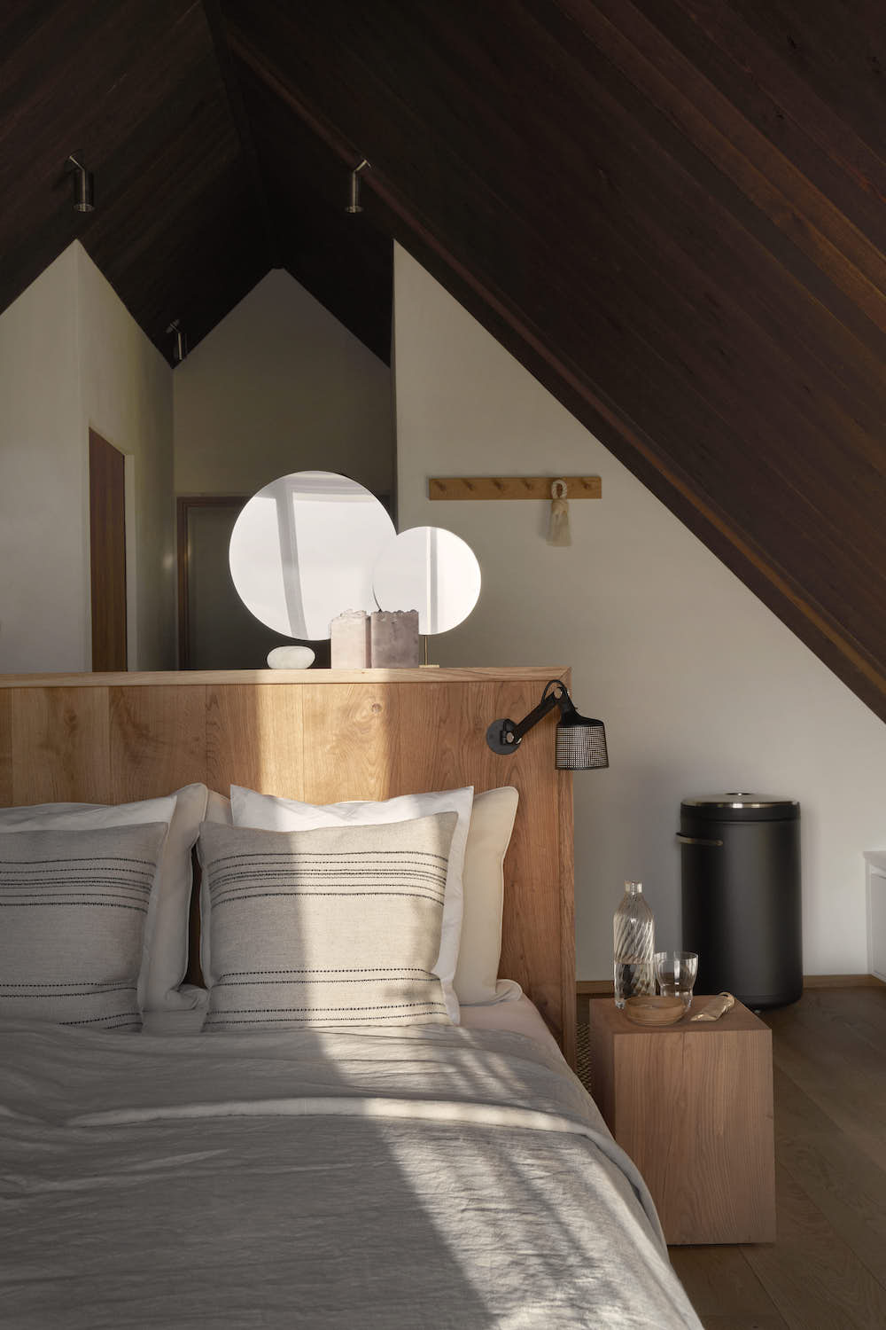 Bed in en suite bedroom with wooden headboard and nightstand.