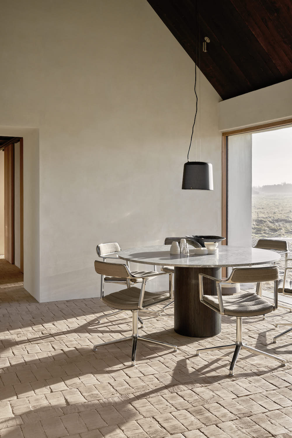 A dining room with a large table and chairs.