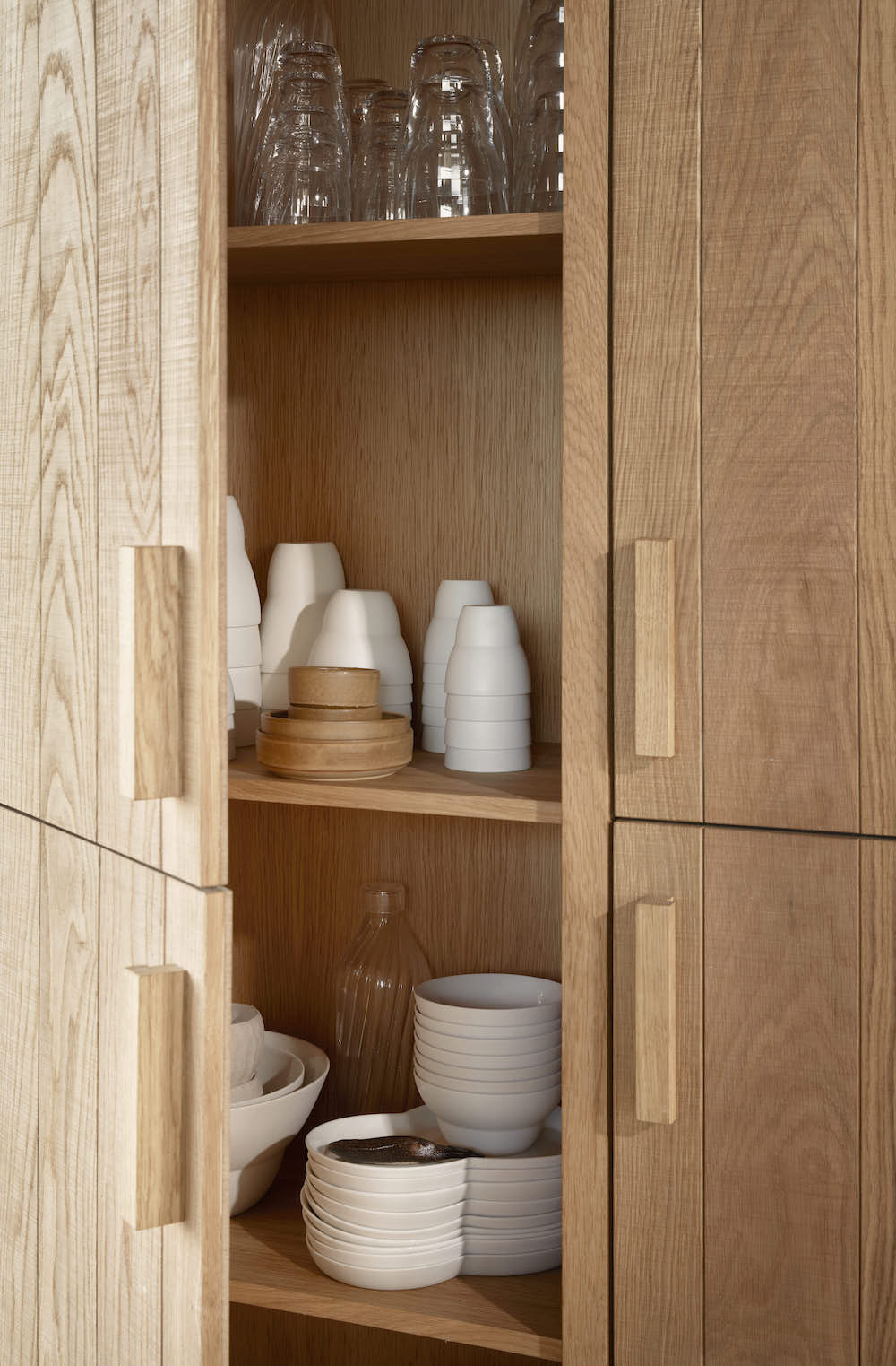 A peek inside oak cabinets reveals drinkware.