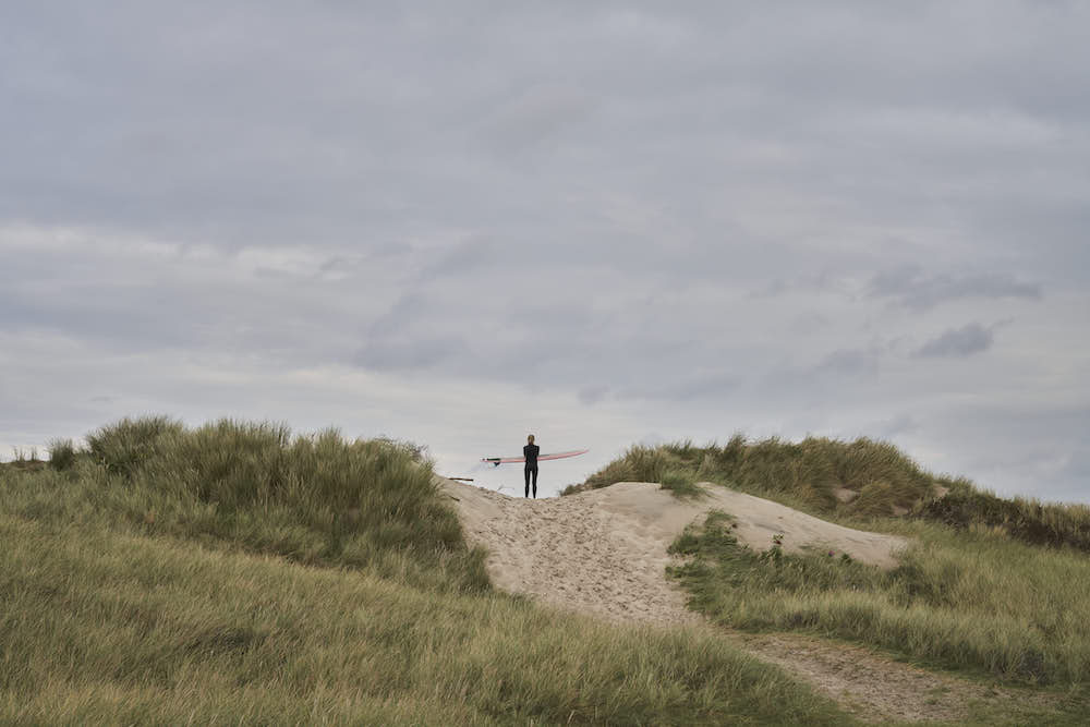 A surfer on a dune.
